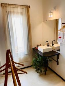 een badkamer met een wastafel, een spiegel en een raam bij Morada IKIGAI KiteHouse in Prea