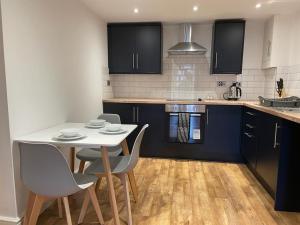 a kitchen with a white table and chairs in it at Newly rennovated 1-bedroom serviced apartment, walking distance to Hospital or Train Station in Newport