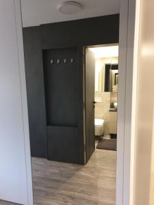ein Bad mit einer schwarzen Tür und einem WC in der Unterkunft Apartma Vič Ljubljana in Ljubljana
