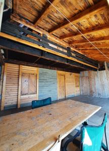 a large wooden table in a room with wooden ceilings at Vikendica A Vlasic in Vlasic
