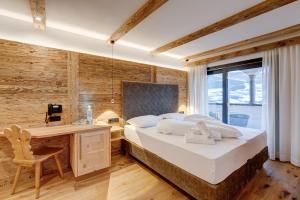 a bedroom with a large bed and a desk and a desk at Hotel Residence Gasser in Villandro