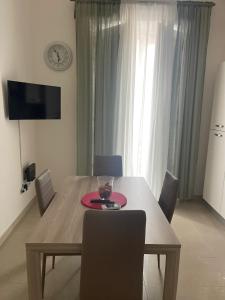 una mesa de comedor con sillas y un plato. en PALAZZO MAZZINI 2, en Caserta