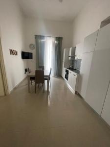 Una sala de estar con una mesa y una cocina. en PALAZZO MAZZINI 2, en Caserta 5 fotos más
