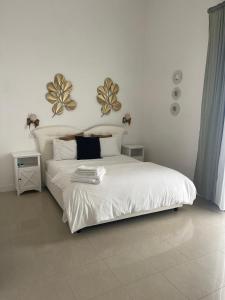 Un dormitorio con una gran cama blanca con dos espejos en la pared. en PALAZZO MAZZINI 2, en Caserta