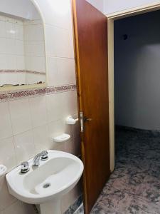 y baño con lavabo blanco y espejo. en Alquiler en el CENTRO Luz en Río Gallegos
