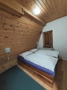 a bedroom with a bed in a wooden room at Vikendica A Vlasic in Vlasic