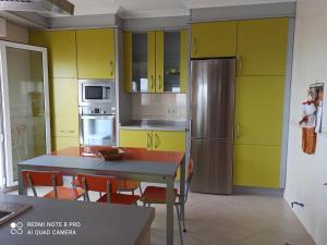 une cuisine avec des armoires jaunes, une table et des chaises dans l'établissement CASA CON ESPECTACULARES VISTAS AL MAR, à Escarabote