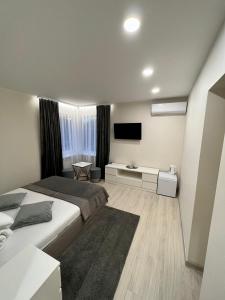 1 dormitorio con 1 cama grande y TV de pantalla plana en 11B Svečių namai Palanga en Palanga