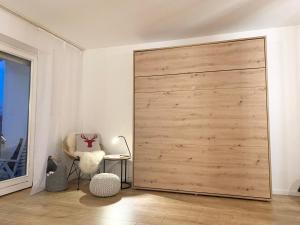 a large wooden sliding door in a room with a chair at FeWo Alpenwiese mit Hallenbad&Sauna in Missen-Wilhams