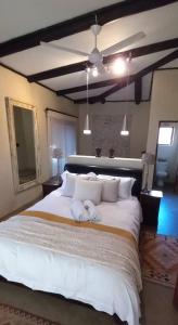 a bedroom with a large white bed with towels on it at Bee-Eater Cottage, DaGama Dam in White River