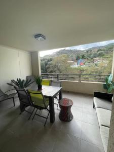 Cardo的住宿－Appartement calme proche Bastia，客房设有桌椅和阳台。