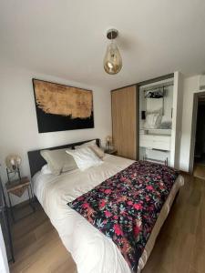 sypialnia z łóżkiem z kwiatowym kocem w obiekcie Appartement calme proche Bastia w mieście Cardo