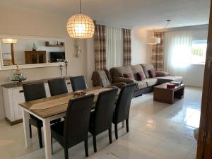 uma sala de estar com uma mesa e cadeiras e um sofá em Agradable casa con piscina em Bolnuevo