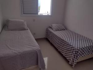 1 dormitorio con 1 cama y 1 silla en Apto Centro Bertioga, en Bertioga
