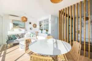 un soggiorno con tavolo e sedie bianchi di Cachirulo Deluxe Apartment 13-B Levante Beach a Benidorm