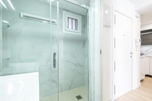 bagno con doccia e porta in vetro di Cachirulo Deluxe Apartment 13-B Levante Beach a Benidorm