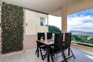 a dining room with a table and chairs and a large window at Pura Vida Terraza Vistas Mar y Montaña, Piscina, Parking by Vero in Altea la Vieja
