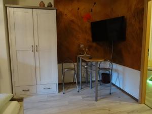 ein Wohnzimmer mit einem Tisch und einem TV in der Unterkunft Pension & Gästehaus Paffrath in Großbrembach