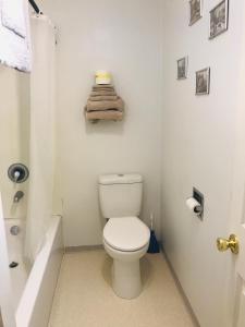 La salle de bains blanche est pourvue de toilettes et d'une baignoire. dans l'établissement Black Hills Motel at Quail's Crossing, à Hill City