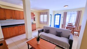 ein Wohnzimmer mit Sofa und Tisch in der Unterkunft La Graciosa Camelia Beach Vistas Mar in Caleta de Sebo