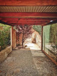 an empty patio with a brick wall and a tree at HERMOSO ALOJAMIENTO TEMPORARIO KAYA in Villa Giardino
