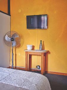 1 dormitorio con TV y mesa con ventilador en HERMOSO ALOJAMIENTO TEMPORARIO KAYA en Villa Giardino