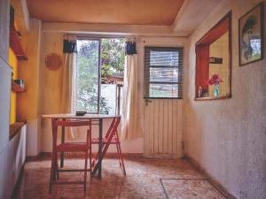 una mesa y una silla en una habitación con ventana en HERMOSO ALOJAMIENTO TEMPORARIO KAYA en Villa Giardino