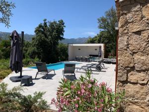 a patio with chairs and a swimming pool at DOMAINE NAPOLEON CORSICA FIGARI in Figari