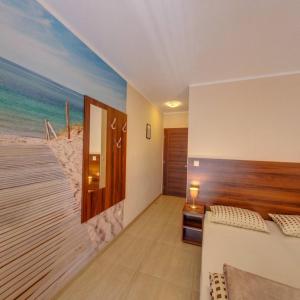 a room with a bedroom with a beach mural at Willa Amber in Rowy