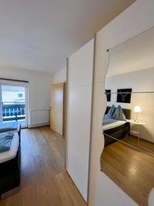 a small room with two beds and a room with a window at Peters Panoramaappartment in Piesendorf