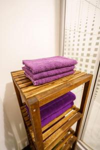 een stapel paarse handdoeken op een houten kar bij Two bedroom Ausekla apartment in Liepāja