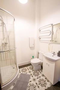een badkamer met een douche, een toilet en een wastafel bij Two bedroom Ausekla apartment in Liepāja