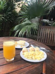 una mesa con dos platos de comida y un vaso de zumo de naranja en Pousada São Jorge, en Bonito