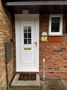 a white front door of a brick house at Victoria Gardens in Colchester