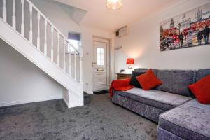 a living room with a couch and a staircase at Victoria Gardens in Colchester