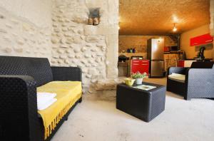 Il comprend un salon doté d'un mobilier noir et d'une cuisine. dans l'établissement Les Figuets, à Châteauneuf-de-Galaure