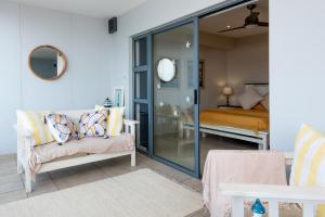 a living room with a couch and a bedroom at INDIGO BAY 24 in Margate +11 photos