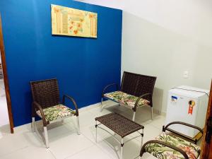 a room with three chairs and a blue wall at Hotel Solar Dos Viajantes in Águas Formosas