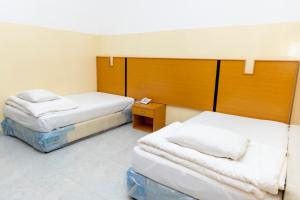 ein Hotelzimmer mit 2 Betten und einem Nachttisch in der Unterkunft Al Ghaba Line Hotel 