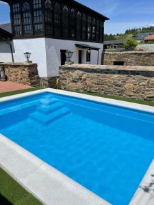 una piscina azul frente a una casa en Casona Las Burillas, en Villar de los Barrios
