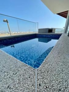 - une piscine avec des carreaux bleus dans un bâtiment dans l'établissement ¡A 3 minutos de la Playa! Hermoso Departamento de Estreno con Piscina y Parrilla, à Asia