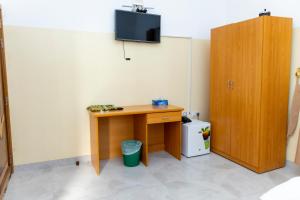 Zimmer mit einem Schreibtisch und einem TV an der Wand in der Unterkunft Al Ghaba Line Hotel 