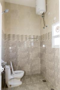 ein Badezimmer mit einem weißen WC und einer Dusche in der Unterkunft Al Ghaba Line Hotel 