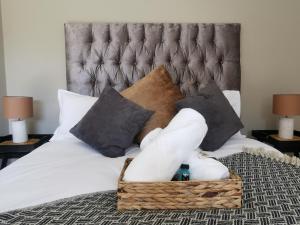 a bed with a basket of towels and pillows at Bosveld In Die Stad 2 in Alberton