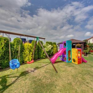 a playground with a slide and a swing set in a yard at Willa Amber in Rowy