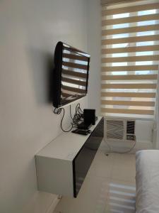 a tv sitting on a desk in a bedroom at Birch Tower by Tristoff in Manila