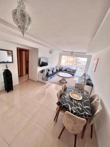 a living room with a table and a couch at The blue pearl-Sensational beach apartment in Aourir in Agadir