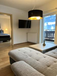 a living room with a couch and a large window at Peters Panoramaappartment in Piesendorf