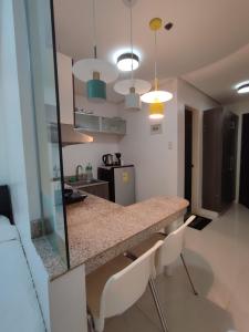 a kitchen with a counter and chairs in a room at Birch Tower by Tristoff in Manila