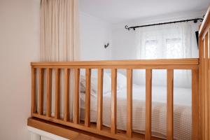 a wooden crib in a bedroom with a window at Garifalakis House in Pollonia